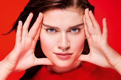 Modelo con manos alrededor del rostro